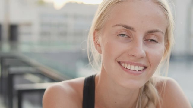 Closeup beautiful blond lady looking at camera with toothy smile, femininity
