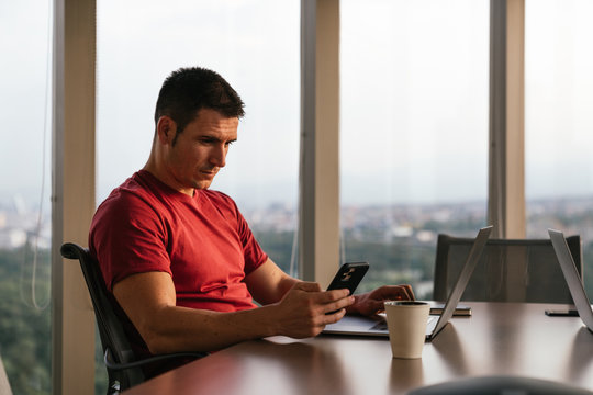 caucasian man in an indoor office with view of city