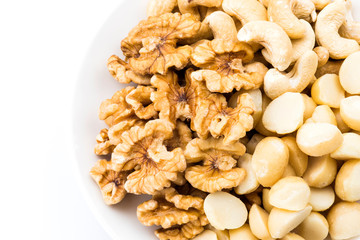  Some cashews, macadamias, and walnuts on a white dish.