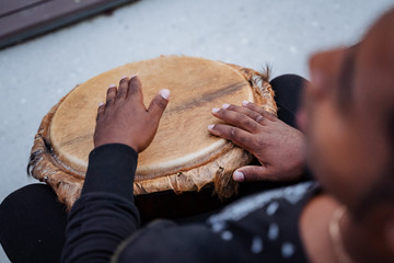 play with your hands on the drum, an African-American plays the djembe drum, top view, close-up