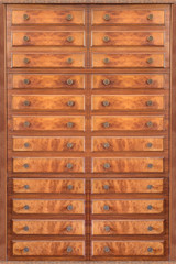 Old wooden cupboard door full of small drawers. A pattern of lines and circles of vintage furniture. Geometric and hypnotic background.