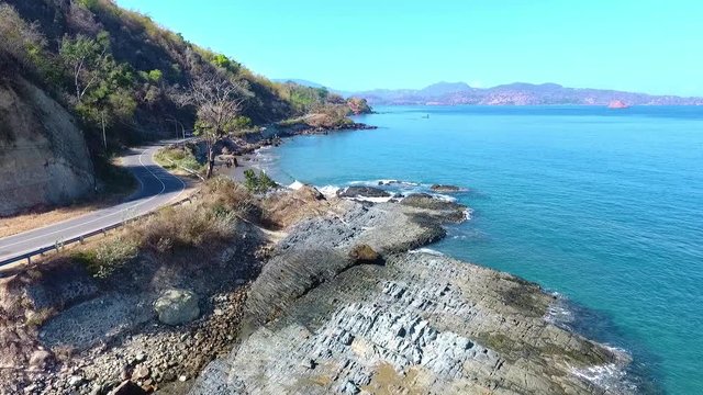 Aerial view following the coast road along the shores of Poto Batu, West Sumbawa Indonesia