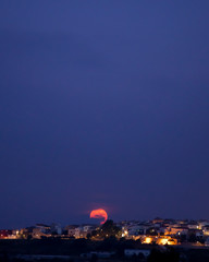 Obraz premium full moon rising over the horizon of a town