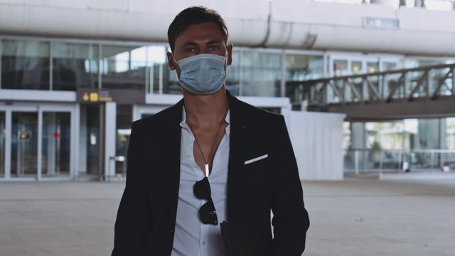 Man in Surgical Mask and Business Suit Walking with Airport Departure Area