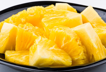 Sliced pineapple on a white plate, it is a sweet and juicy fruit.