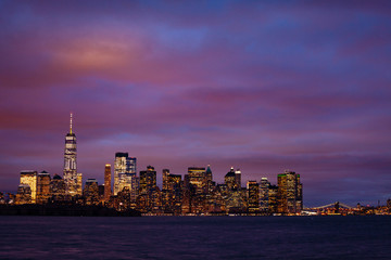 Obraz premium Wide panorama of a moody night view of New York Manhattan downtown over Hudson river