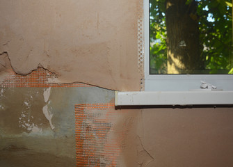 Applying coat of plaster on the wall in the problem area around the window and under the window sill using self-adhesive fiberglass mesh and angle beads.
