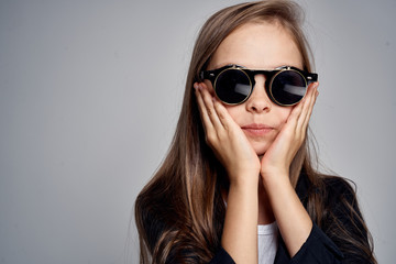 Cute schoolgirl wearing sunglasses childhood learning school light background
