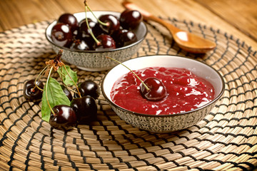 homemade cherry jam with fruit around - closeup