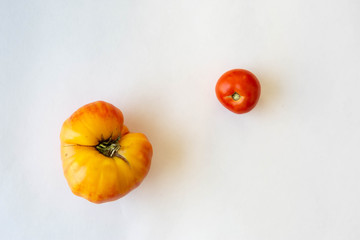 Yellow and red tomatoes on white background.