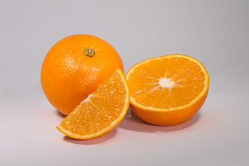 set of two oranges, one whole and the other cut in half