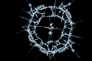 pattern from the impact of a broken mirror and glass on a black background in cracks in the form of an isolated image abstraction