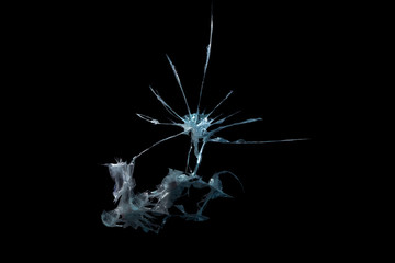 pattern from the impact of a broken mirror and glass on a black background in cracks in the form of an isolated image abstraction
