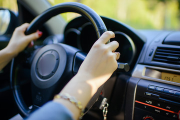 Female hands over a wheel in the car, close up
