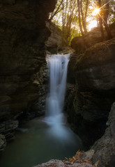 High quality landscape photo for a beautiful natural waterfall/cascade during the golden hour/afternoon with waters running dreamily through a mountain in Grenoble/France at Les Cuves de Sassenage
