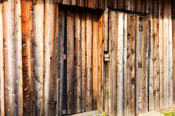 Wooden door in old village barn from damaged boards.