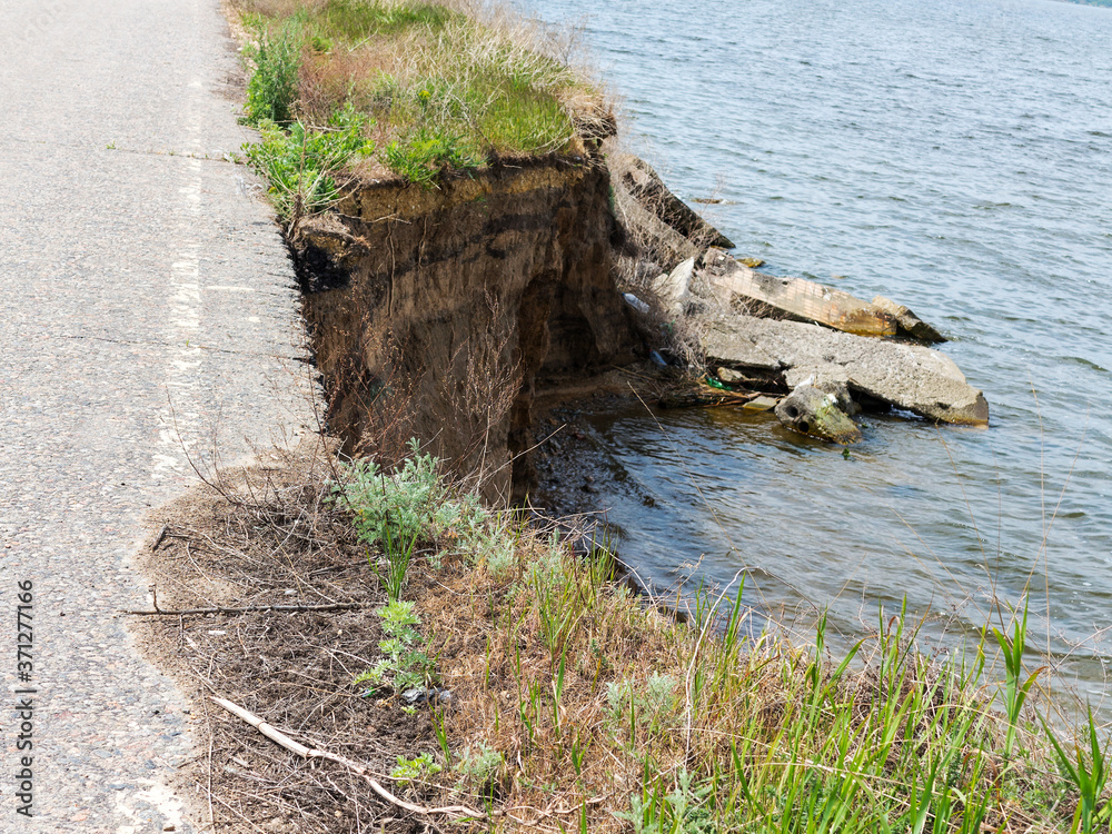 Wall mural deep sandy cliff on the background of blue sky. the destruction of the coast as a consequence of soi