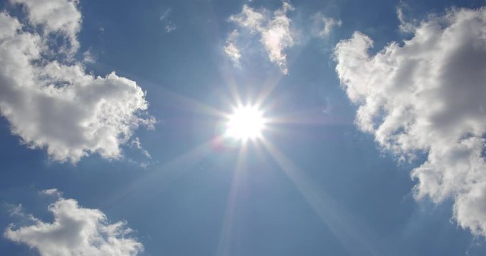 Summer sun and clouds on the blue sky.