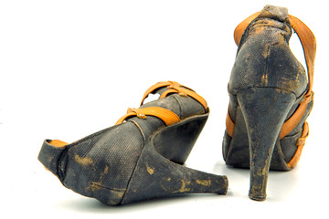 Close-up of old and dirty woman high heel shoes on the white background.