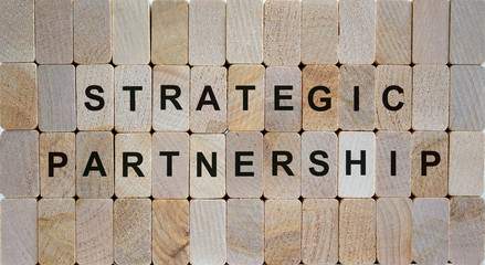 Wooden blocks form the words 'strategic partnership'. Beautiful wooden background. Business concept.
