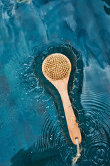 A natural bristle brush rests on the water in the pool. Zero waste concept.