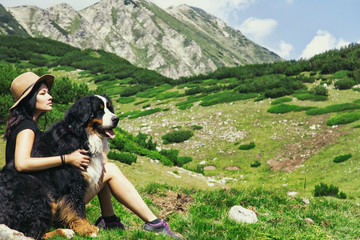 Naklejka na ściany i meble Girl with a dog on the background of a mountain landscape in Bulgaria