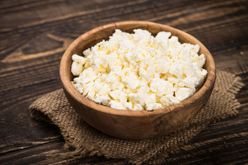 Curd or cottage cheese at wooden table.