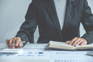 businesswomen bookkeeper use calculator and laptop doing account for paying tax on white desk in working office
