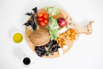board with groceries on it. view from above. tomatoes, onions, coconut, cabbage, mushrooms