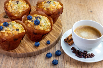 blueberry muffins with cup of cinnamon coffee on wooden table