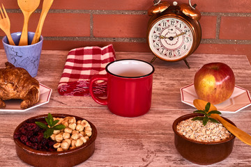 Breakfast with croissant, apple, hazelnuts, blueberries and oatmeal.