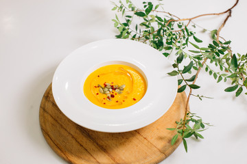 a plate of pumpkin soup garnished with pumpkin seeds.