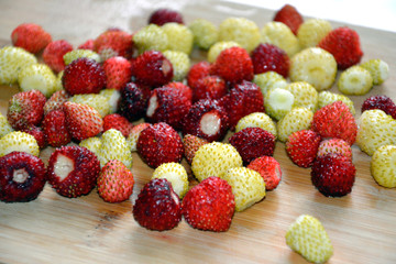 Ripe strawberries close-up lie on the wooden surface. Red and white berries.