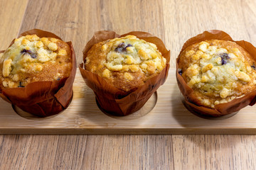 blueberry muffins lined up on wooden table