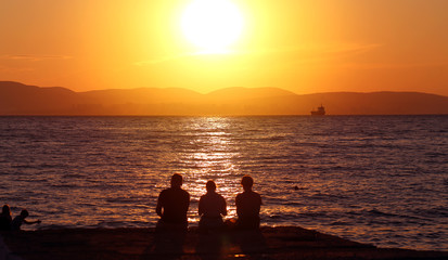Photo landscape sunset on the sea with a group of people