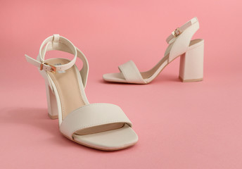 womens high heels sandals
One pair of white women's sandals with high and square heels stands on a...