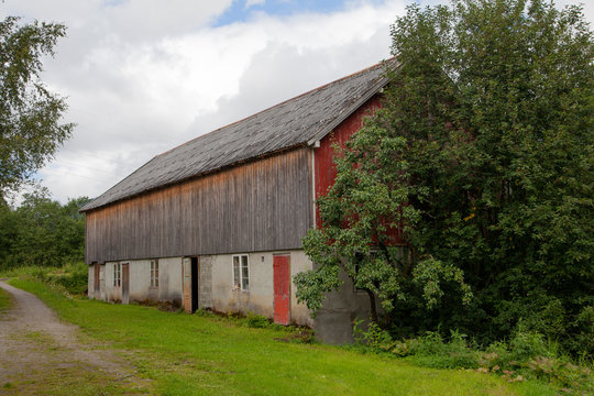 The barn on an old abandoned farm. It is unpainted and about to decay