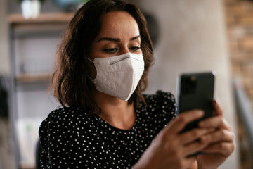 Beautiful businesswoman with medical mask working in office. Young businesswoman uing the phone.