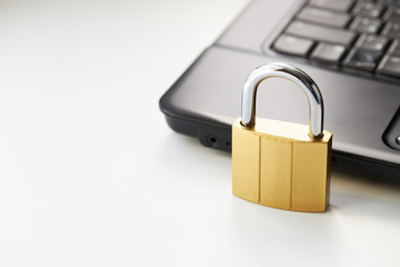 golden padlock on a black laptop keyboard over white background. internet security concept. antivirus software concept. electronic wallet symbol