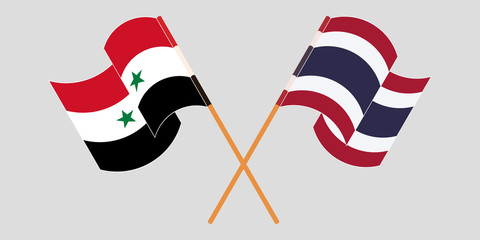 Crossed and waving flags of Syria and Thailand