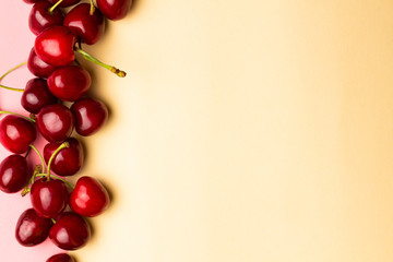 Cherry berries on a yellow background top view.Background with a cherry on a sprig, flat lay.
