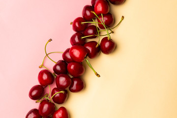 Cherry berries on a yellow background top view.Background with a cherry on a sprig, flat lay.