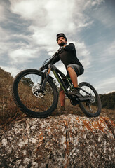 Fototapeta premium Confident male cyclist on bike in mountains