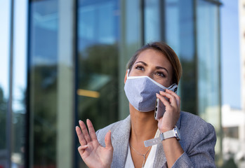 Business woman with protective mask talking on phone outdoor