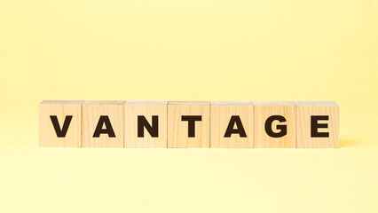 word vantage with small wooden blocks on yellow background