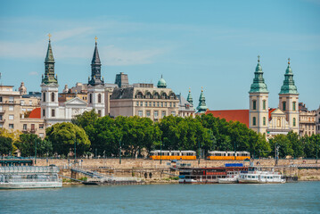 Fototapeta premium Budapest, Hungary. Church by Danube River, old typical yellow tram in the city. Elisabeth bridge and Parish church.