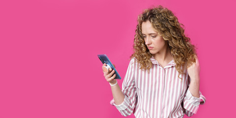 Fashionable woman in a striped shirt, reads a message on the phone.