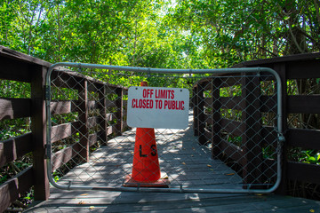 A Boardwalk With a Fenced Off Section With a Sign Stating That It's Off Limits and Closed to the Public