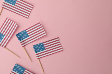 American flags on pink background, space for text