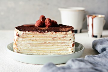 Crepe cake made of thin Crepe with butter cream, cocoa, chocolate,freeze-dried strawberries. Delicious dessert from French crepes. Tiramisu cake made of thin pancakes.